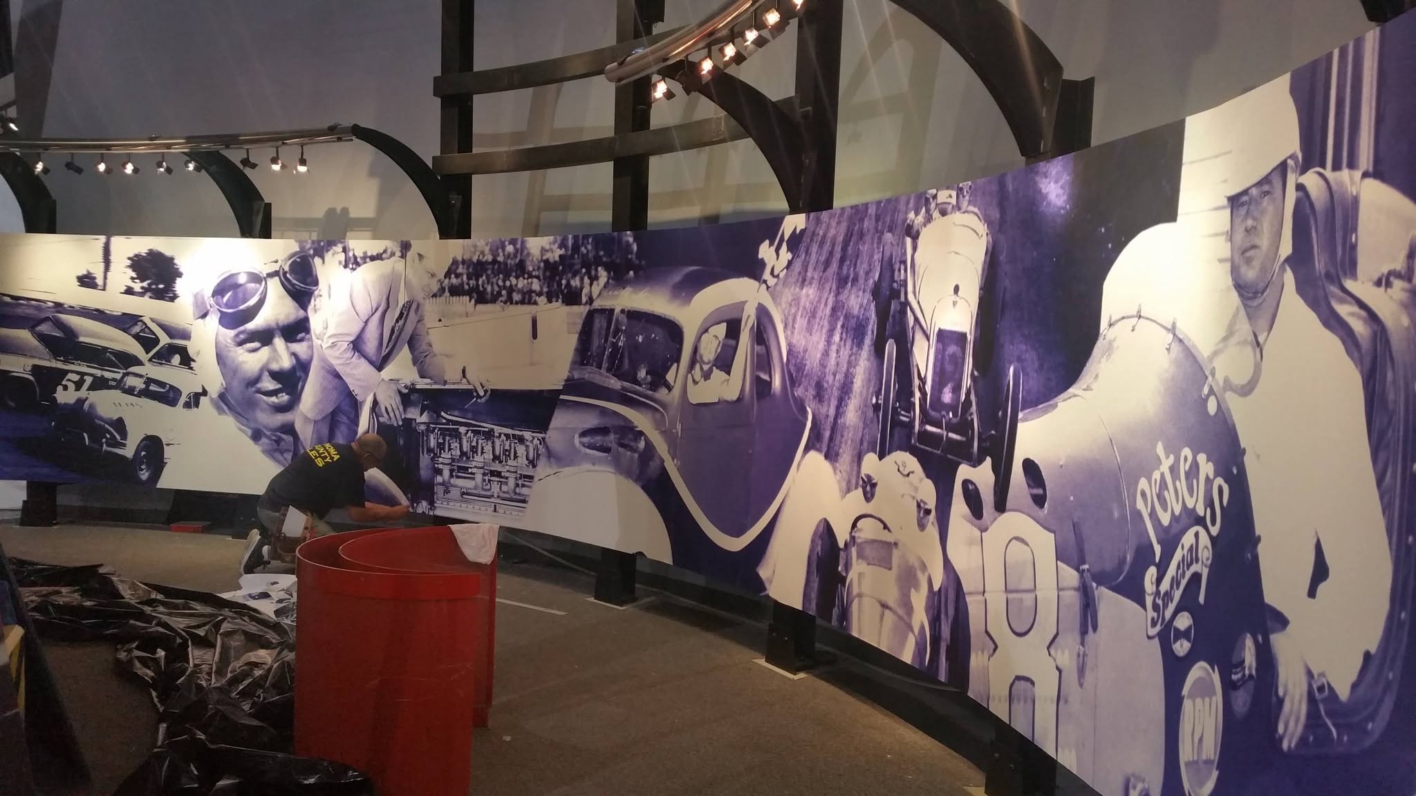 Large curved motorsports mural installed in a commercial interior